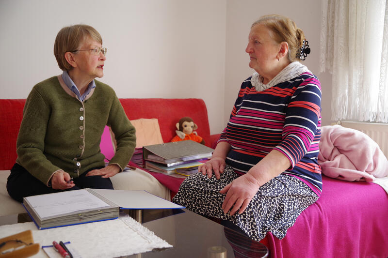 s:62:"Elisabeth Träder (li.) hilft Jasenka M. (re.) bei ihrer Post.";