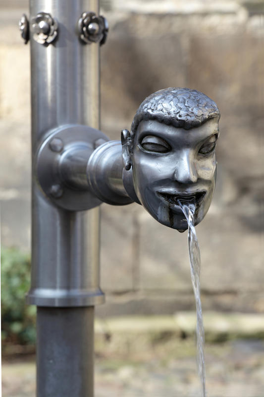 s:65:"Wasserspeier an einem Brunnen in der Altstadt von Pirna, Sachsen.";